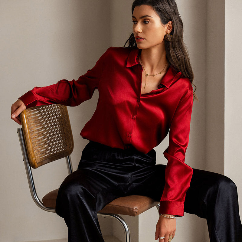 Elegant model wearing a luxurious red silk blouse with black silk pants, showcasing the rich luster and drape of high-quality silk fabric in formal attire