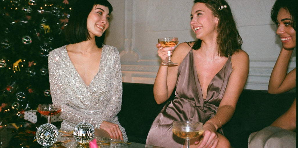 A group of women in elegant silk slip dresses, enjoying a glamorous party moment, showcasing the dress's charm for sophisticated social events.