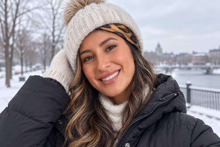 A person wears a silk square scarf beneath a knit winter hat, with the scarf visible at the hairline.