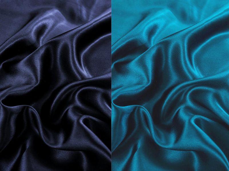 Close-up of navy and teal silk fabric showing sheen, texture, and drape