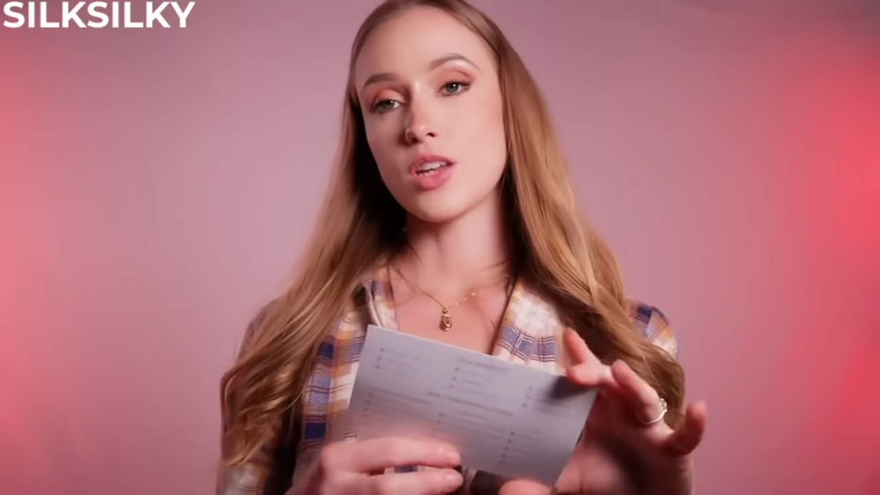 Model with long hair wearing a plaid shirt, holding what appears to be a product information sheet or review card for SILKSILKY products against a pink background
