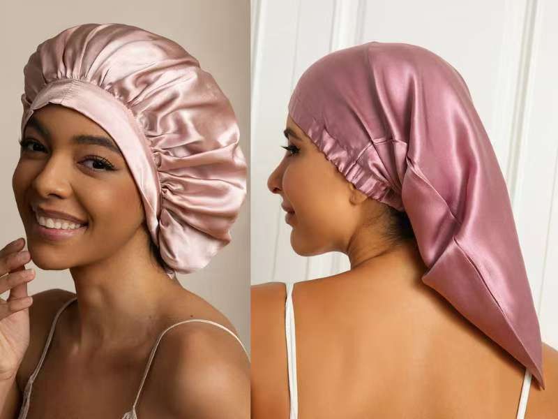 Two different styles of shiny pink silk bonnets shown on a person's head against a plain background