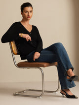Woman wearing a white silk V-neck long sleeve cardigan with button front