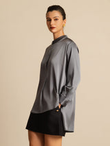 Blush pink silk blouse with stand collar, button front, long sleeves, and high-low hem