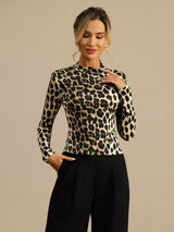 Woman wearing a black and white wild animal print silk mock neck top