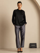 Woman wearing a white gathered neck long sleeve silk blouse with button detail
