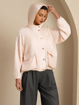 Black silk hooded jacket with large flap pockets, button closure, and drawstring hem