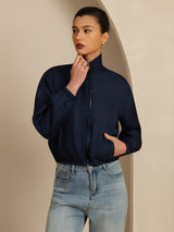 Woman wearing a red silk reversible jacket with stand collar, zipper, and pockets