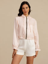 White silk cropped hooded jacket with pockets, zipper, and ruffled cuffs